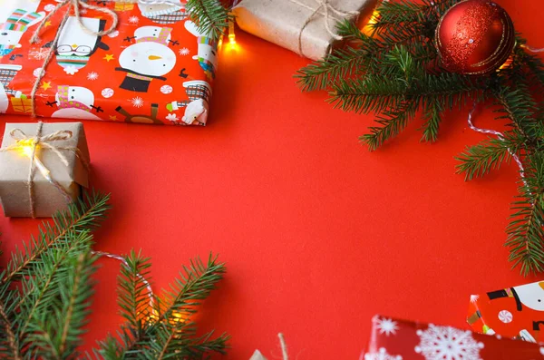 ギフトボックス ロープの爪 紙のロールと装飾 赤い背景のモミの木の枝を持つクリスマスの組成 休日の準備 コピースペース フラットレイアウト レイアウト フラット付きのトップビュー — ストック写真