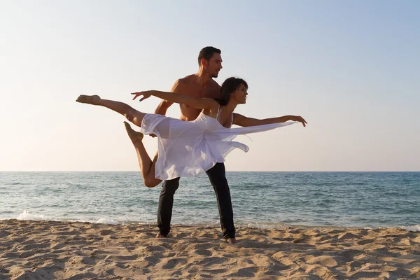 Jong koppel beoefenen van een dance-scene op het strand. — Stockfoto