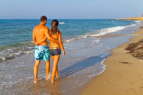 Unga par promenader på stranden — Stockfoto