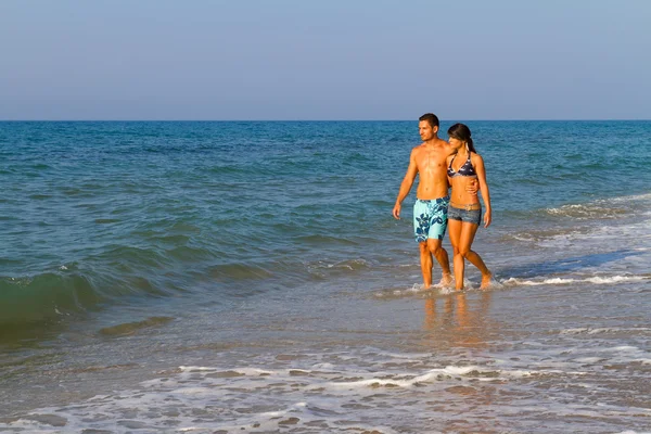 Young couple walking on the beach — Stock Photo, Image