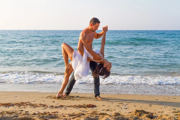 Jong koppel beoefenen van een dance-scene op het strand. — Stockfoto