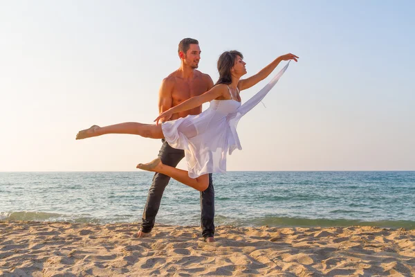 Jeune couple pratiquant une scène de danse à la plage . — Photo