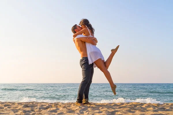 Ungt par kyssar på stranden — Stockfoto