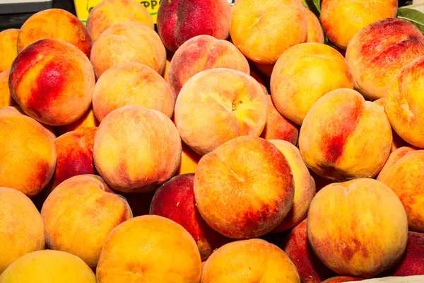 Deliciosos melocotones jugosos frescos en el mercado local de frutas —  Fotos de Stock