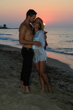 mutlu genç çift sahilde alacakaranlıkta.