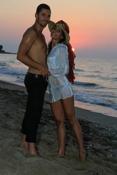 mutlu genç çift sahilde alacakaranlıkta.