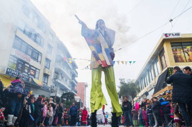 Heraklion, Girit, Yunanistan, 21 Şubat 2015: Karnaval Mardi Gras kutlamaları sırasında yanan meşalelerle yürüyen, ateş yutan ve alevleri dumanla söndüren gösteri sanatçıları.