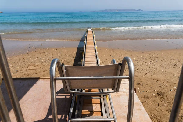Rampe motorisée sécuritaire pour fauteuil roulant, utilisée pour transporter les personnes handicapées dans l'eau de mer pour la natation. Héraklion, Crète, Grèce — Photo