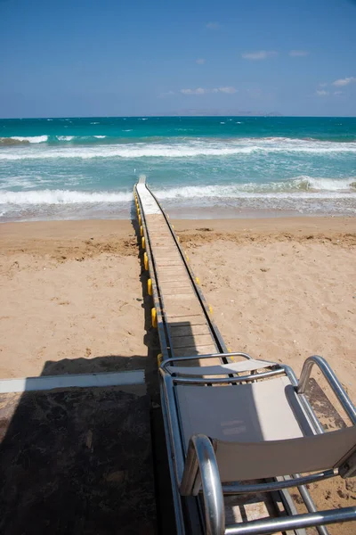 Rampe motorisée sécuritaire avec douche d'eau douce intégrée, utilisée pour transporter les personnes handicapées dans l'eau de mer pour la natation. Héraklion, Crète, Grèce — Photo