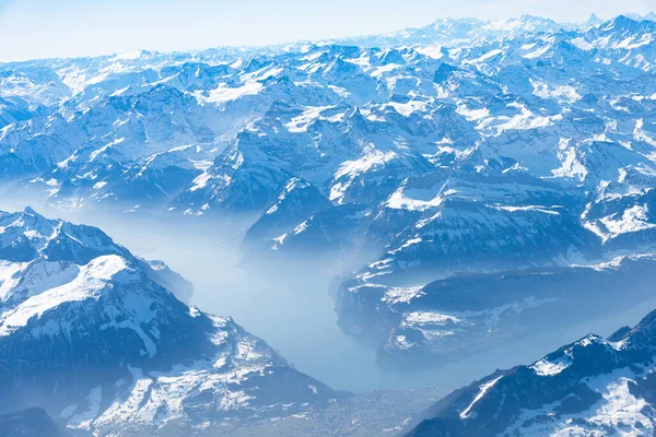 Blå planet jorden unik alpin antenn panorama. Hög höjd antenn syn på snötäckta centrala europeiska Swiiss Alperna sjöar, sett från ett flygplan kabin fönster. Koncept för miljöskydd. — Stockfoto