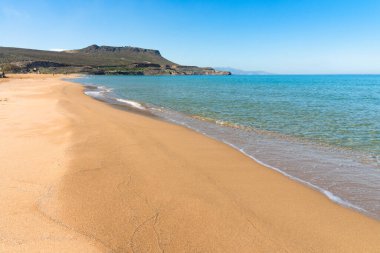 Mediterranean sea, blue sky, crystal clear turquois water and golden sand at Arina sand beach near Heraklion Crete Greece.