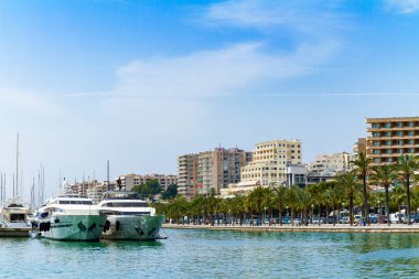 Palma de Mallorca marinasının panoramik gökyüzü manzaralı yelkenlileri. Panorama manzaralı Palma de Mallorca marinası, lüks yelkenliler, balıkçı tekneleri, Castell de Bellver ve Avinguda de Gabriel Roca 'daki oteller.