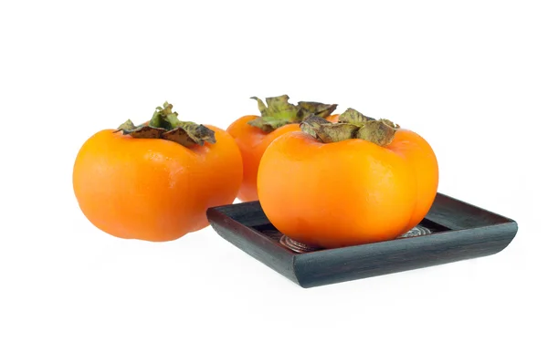 Persimmon on wood plate and white background — Stock Photo, Image