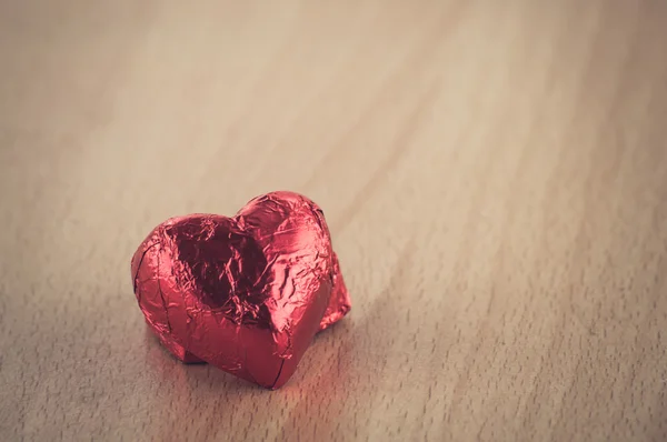 Ahşap masa üstünde kırmızı kalp şekli — Stok fotoğraf