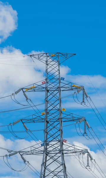 Poste de alto voltaje y cielo azul con nubes blancas — Foto de Stock