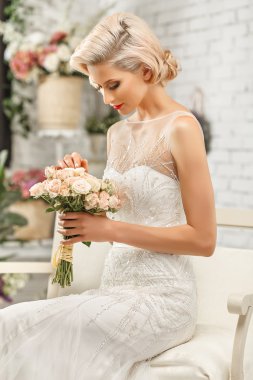 The beautiful  woman posing in a wedding dress