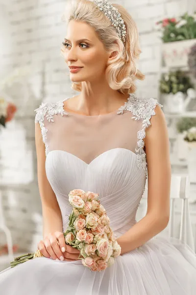 Die schöne Frau posiert im Hochzeitskleid — Stockfoto