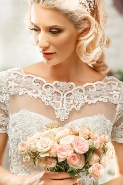 Den vackra kvinnan som poserar i ett bröllopsklänning — Stockfoto