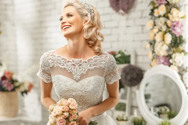 Die schöne Frau posiert im Hochzeitskleid — Stockfoto