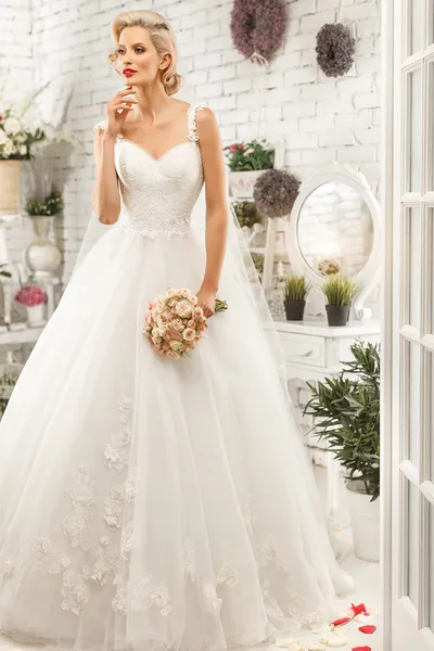 The beautiful  woman posing in a wedding dress — Stok fotoğraf