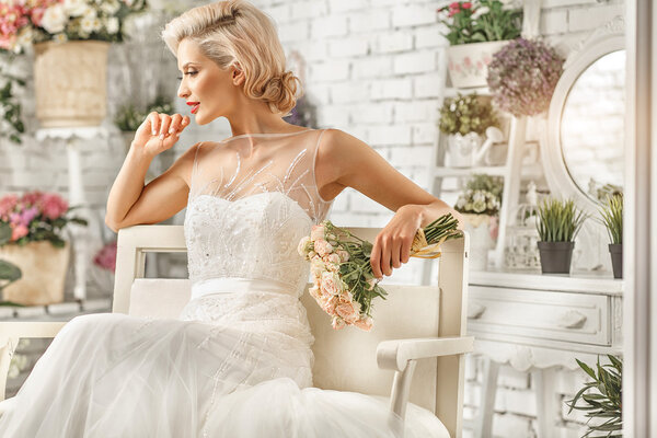 The beautiful  woman posing in a wedding dress