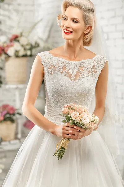 Die schöne Frau posiert im Hochzeitskleid — Stockfoto