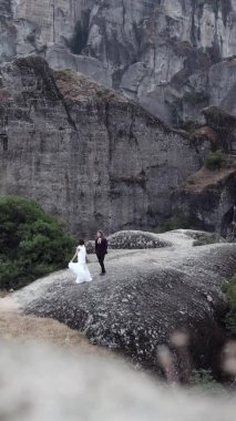 Yeni evli çift ayağa kalkar ve dağlarda eğlenir.