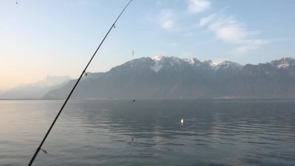 Rybářská prut přes jezero při rybolovu v blízkosti hor — Stock video