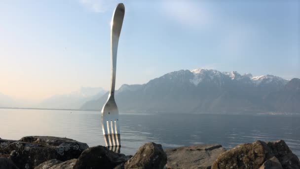 Fork of Vevey estatua en la costa rocosa del lago Ginebra — Vídeo de stock