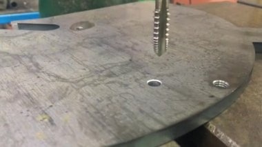 Bir sondaj makinesinde metalde iplik oluşturma süreci.
