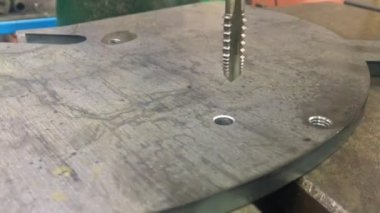 Bir sondaj makinesinde metalde iplik oluşturma süreci.