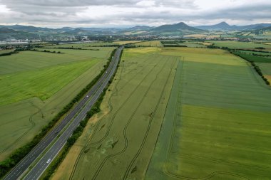 Tarlalar. Yolun yakınındaki buğday tarlaları. Tarlada traktör izleri var. Üst Manzara. Köyün yakınındaki yeşil araziler..