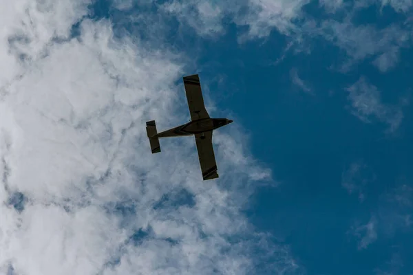 stock image Small plane under the white clouds. Bottom view.. Travel by air. Air sports.