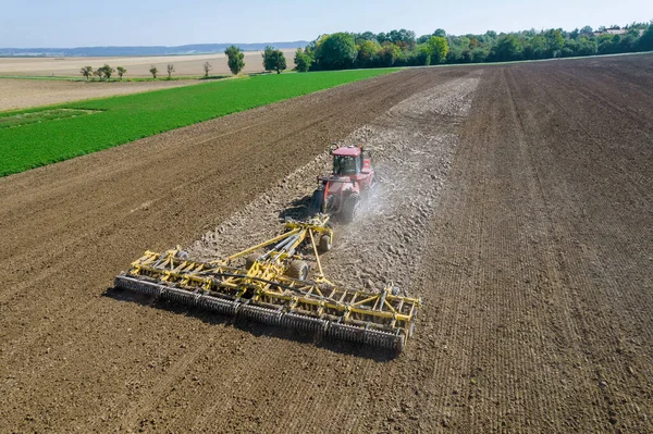 Coltivare la piantagione con un grande trattore in una giornata autunnale. Tillage prima della semina colture invernali. Vista dall'alto. — Foto Stock