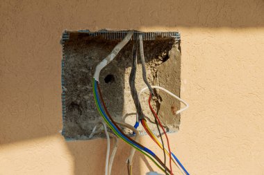 Elektrik kabloları duvardan çıkıyor, bağlantı kuruyor.