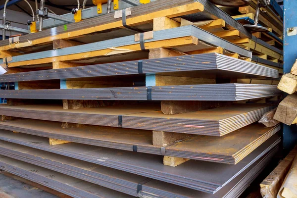Depoda çelik levhalar, rulo metal ürünler. Metal levhalar bir paletin üzerine istiflenmiş. Farklı kalınlıkta birçok metal levha üst üste istiflenmiştir..