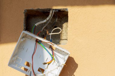 Çalışma duvarında elektrotlar asılı olan bir kalkan. Bir elektrik kartı kurulumu, bir paket anahtarı.