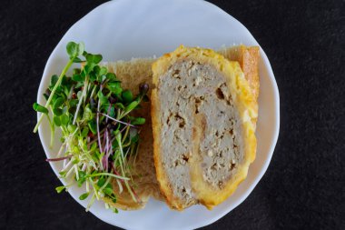 Mikroçipler ve et siyah arka planda beyaz bir tabakta yuvarlanıyor. Lezzetli yemek..