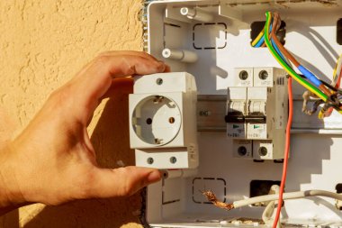 Elektrikçi prizi elektrik paneline yerleştirir..