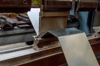 Bending of sheet metal parts using a sheet metal bending machine in factory. Metallurgical industry clipart