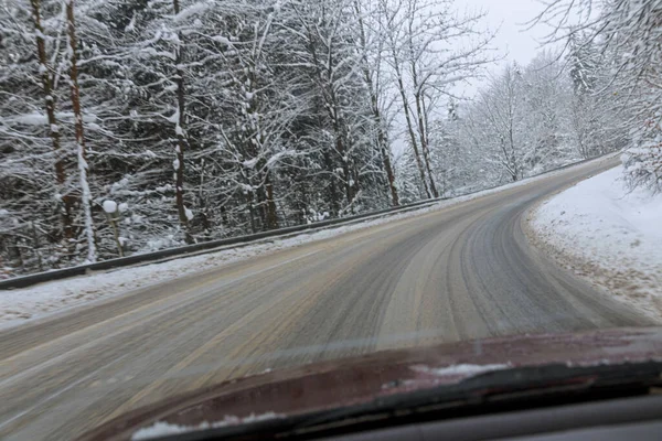 Utsikt Genom Vindrutan Bil Blöt Väg Efter Snö Snötäckta Träd — Stockfoto