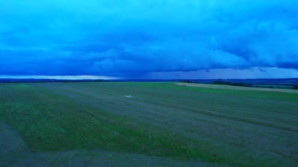 Nuages bleu foncé au-dessus du champ, approchant des orages. Vidéo du drone. — Video
