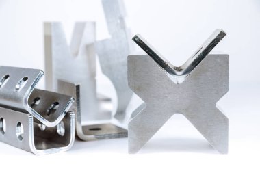 CNC bükme makinesinde beyaz arka planda metal levha bükme ekipmanı. Matris ve eğri ürün