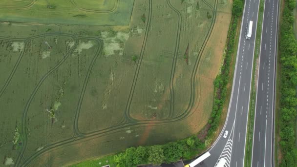 Vista dall'alto di un campo seminato vicino alla strada dove le auto guidano. — Video Stock