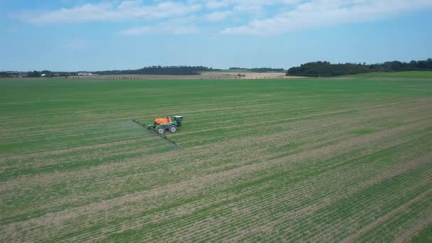 Vista aérea de un fertilizante de pulverización de tractores en plantas agrícolas en el campo. — Vídeo de stock