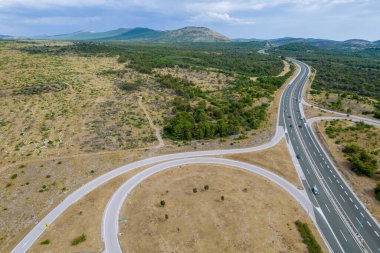 Hırvatistan 'da otoyol. Yeşil çamlar, kayalık dağların yamaçlarında yetişir..