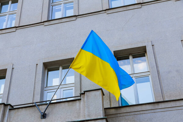 Flag of Ukraine on the background of the house, national flag, state symbol. Place for text.