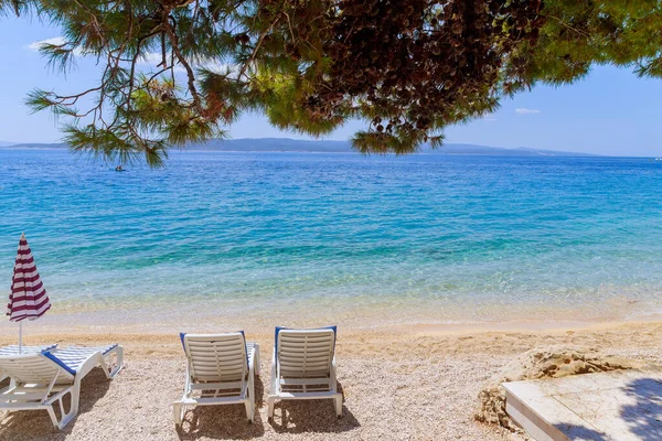 Sunbeds on a sandy beach by the sea. Holidays on the Mediterranean Sea.