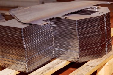 Fabrikada çelik kesen bir makine. Metal parçalar CNC lazer makinesi tarafından ateşleniyor.