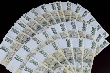 Czech crowns denomination of two thousand. Lots of czech money on a black background. View from above.